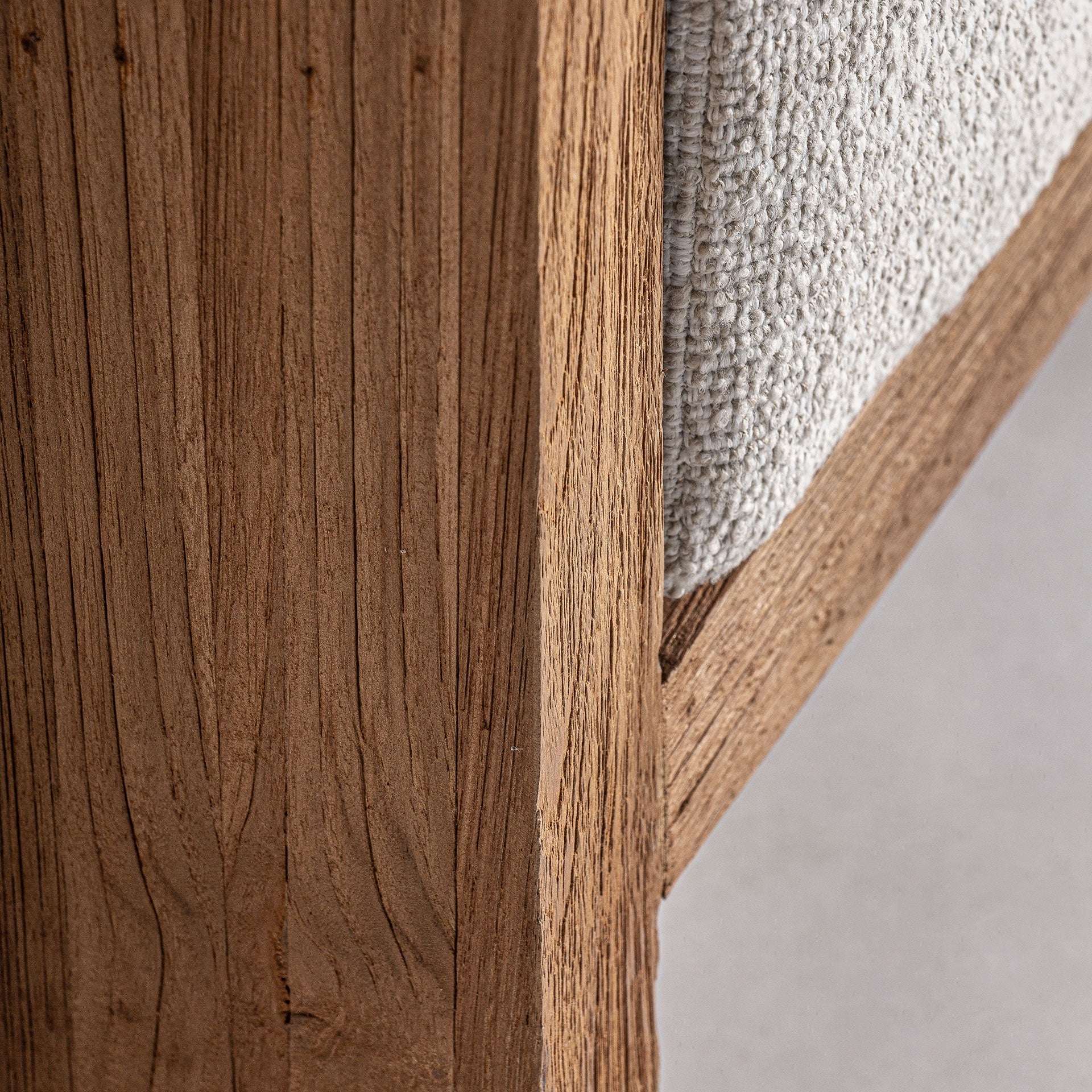 Primer plano de la base del sofá en madera natural, líneas limpias y robustas