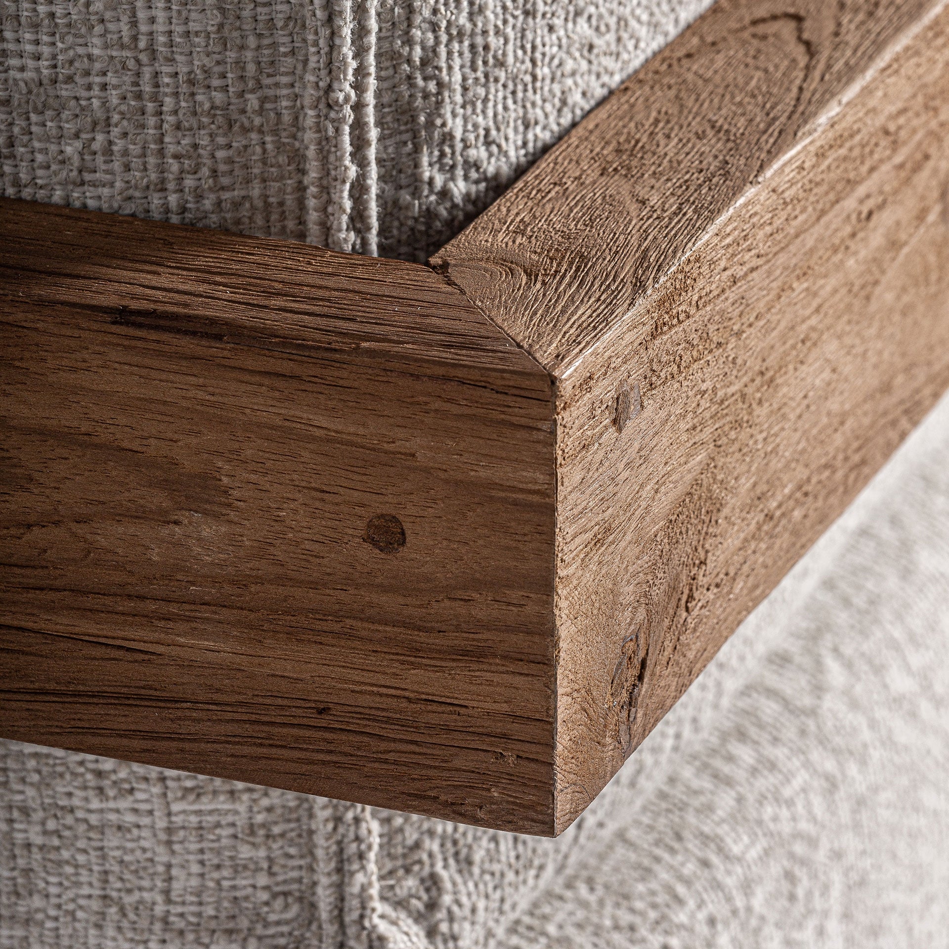 Detalle del soporte modular inferior en madera natural del sofá Testa