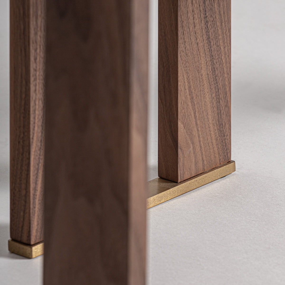 Detalle de la base con patas de madera y remates metálicos dorados, aportando un toque sofisticado a la librería Gifhorn.