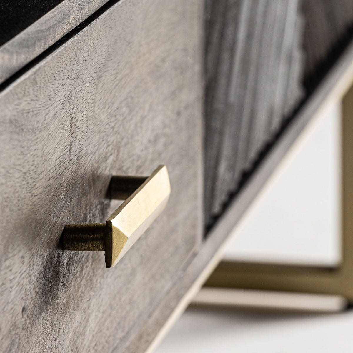 Primer plano del cajón central en madera del mueble TV Kraj, con textura natural y tirador dorado.