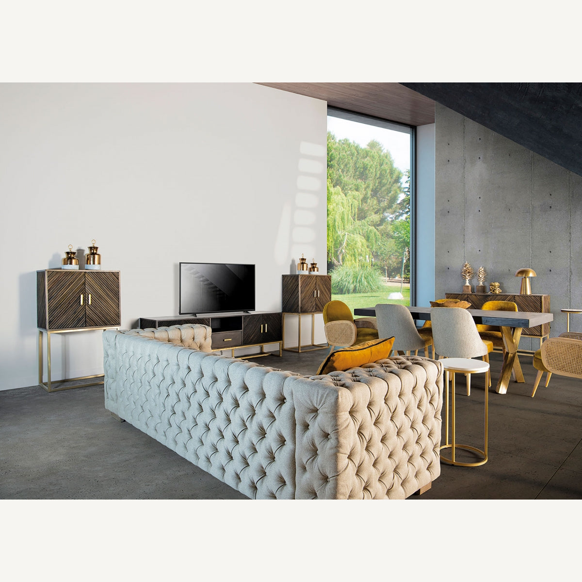 Ambiente completo con el mueble TV Kraj en salón moderno, combinado con piezas doradas y textiles claros.