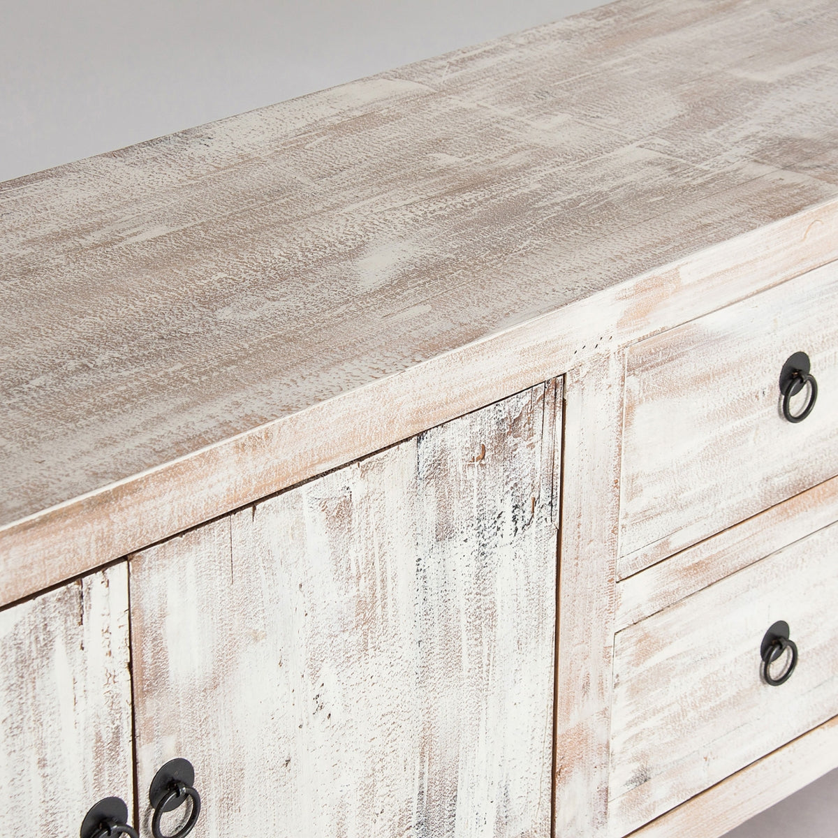 Detalle de la superficie del mueble con textura de madera natural blanqueada, estilo campestre.