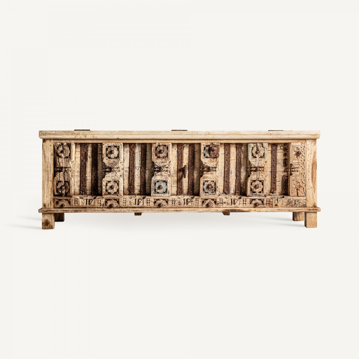 Vista trasera del baúl PHALODI con detalles geométricos tallados y vetas de madera natural en estilo rústico decorativo.
