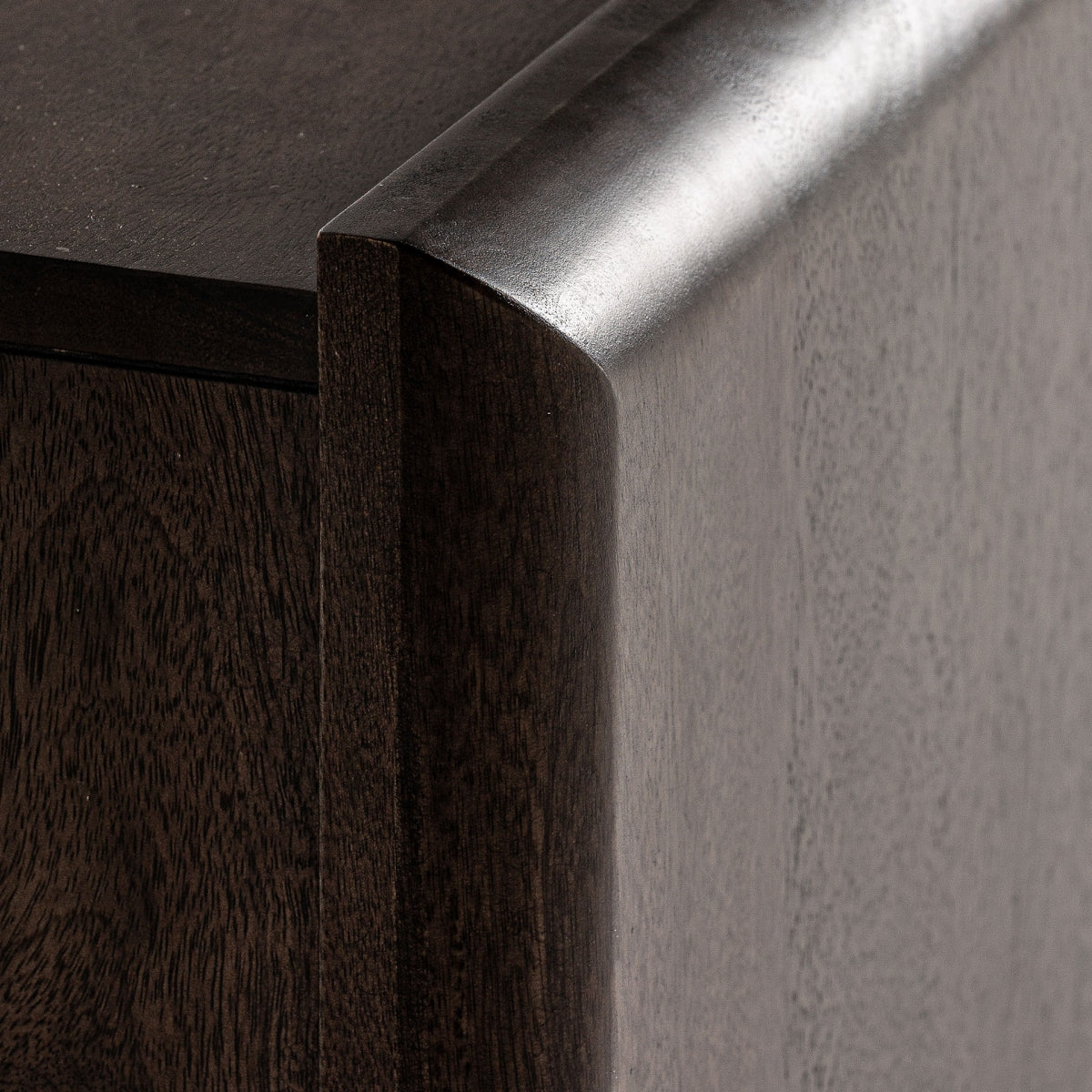 Detalle de las esquinas redondeadas del mueble, acabadas a mano con textura de madera natural.