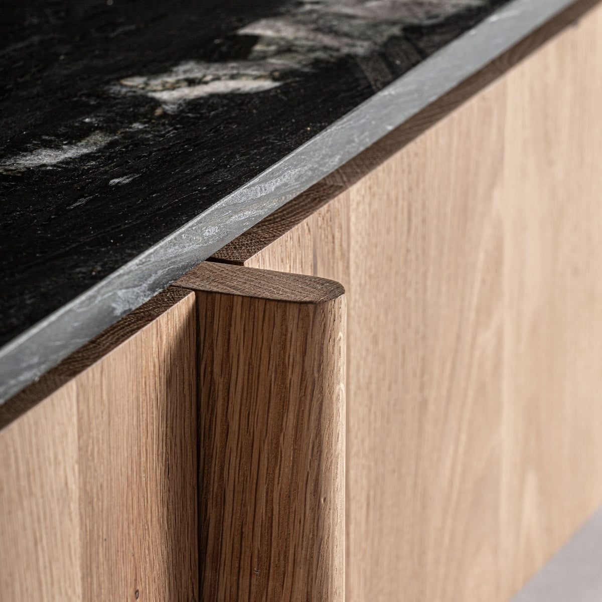 Detalle de tirador integrado en madera curva del mueble Nara, diseño ergonómico y refinado.