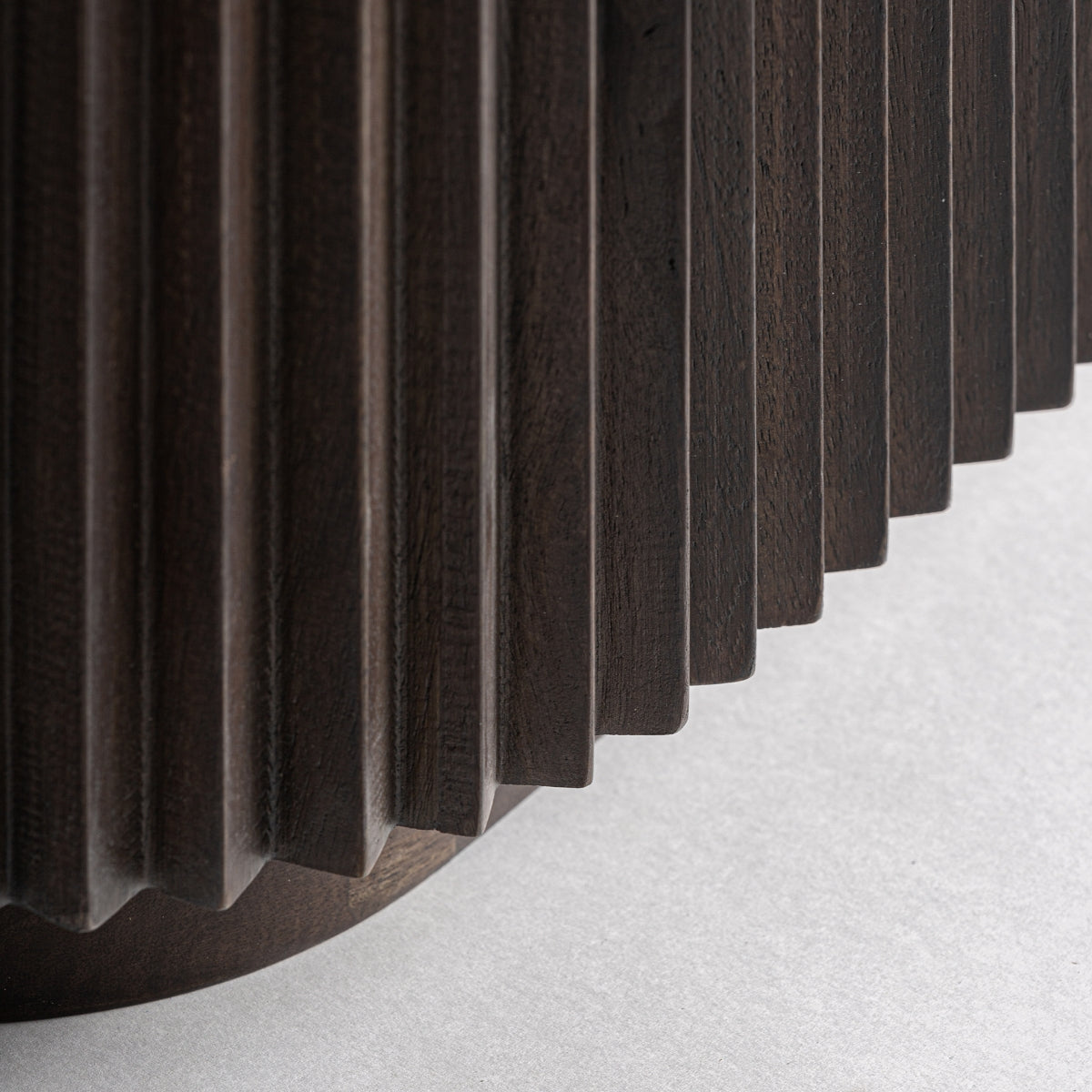 Detalle del lateral acanalado del mueble en madera oscura con acabado sofisticado