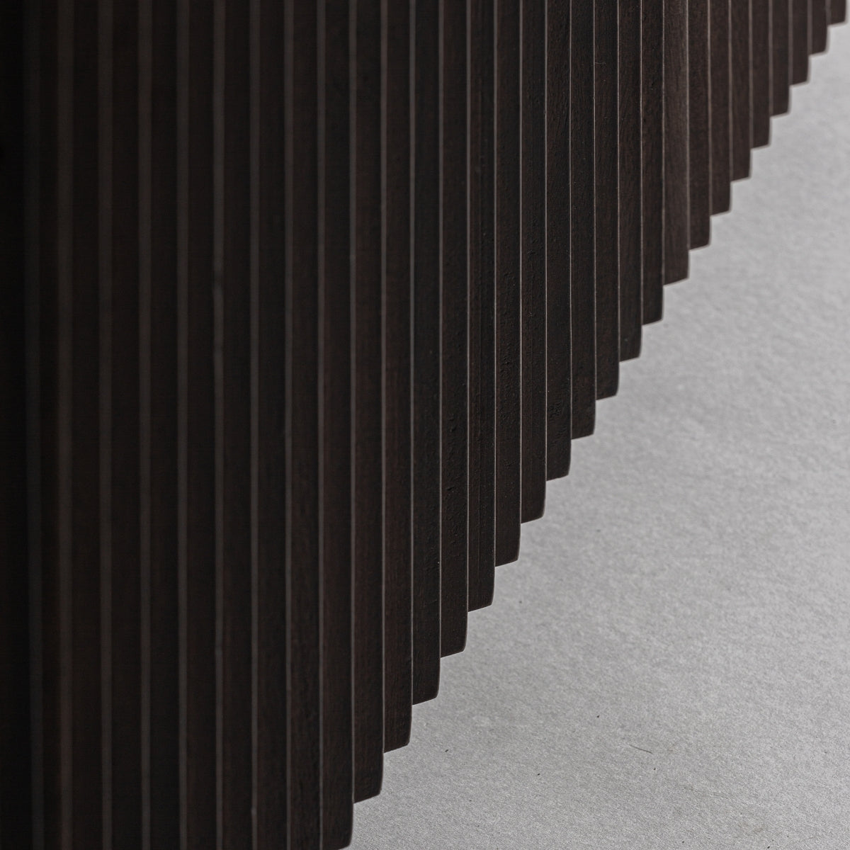 Detalle de la base acanalada en madera oscura, estilo contemporáneo y textura visual