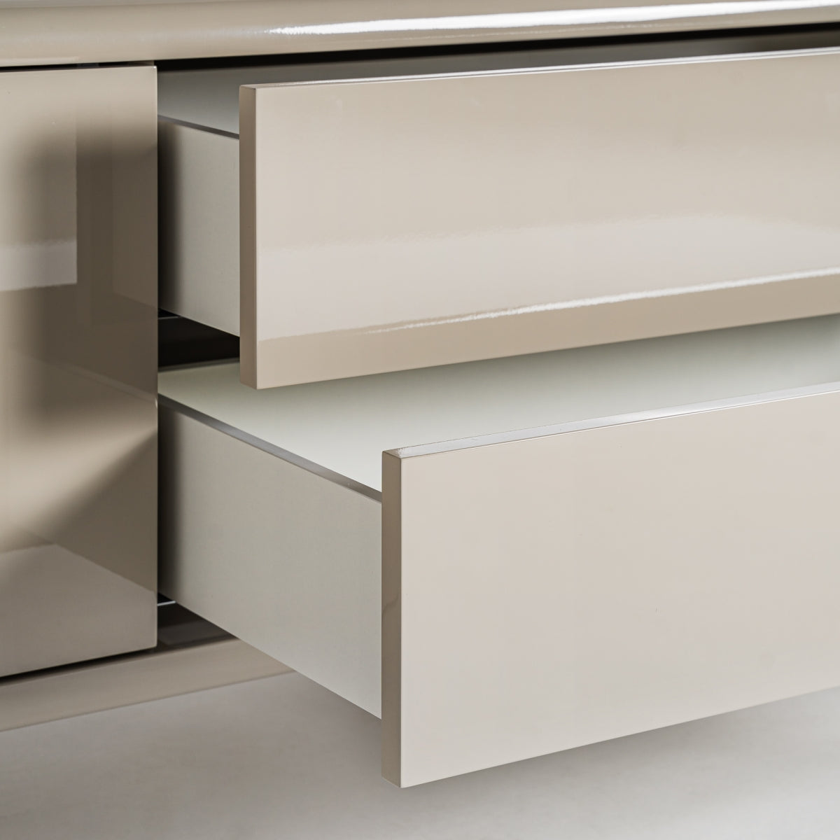 Detalle de los cajones extraíbles del mueble TV lacado en beige. Amplio espacio interior y cierre suave.