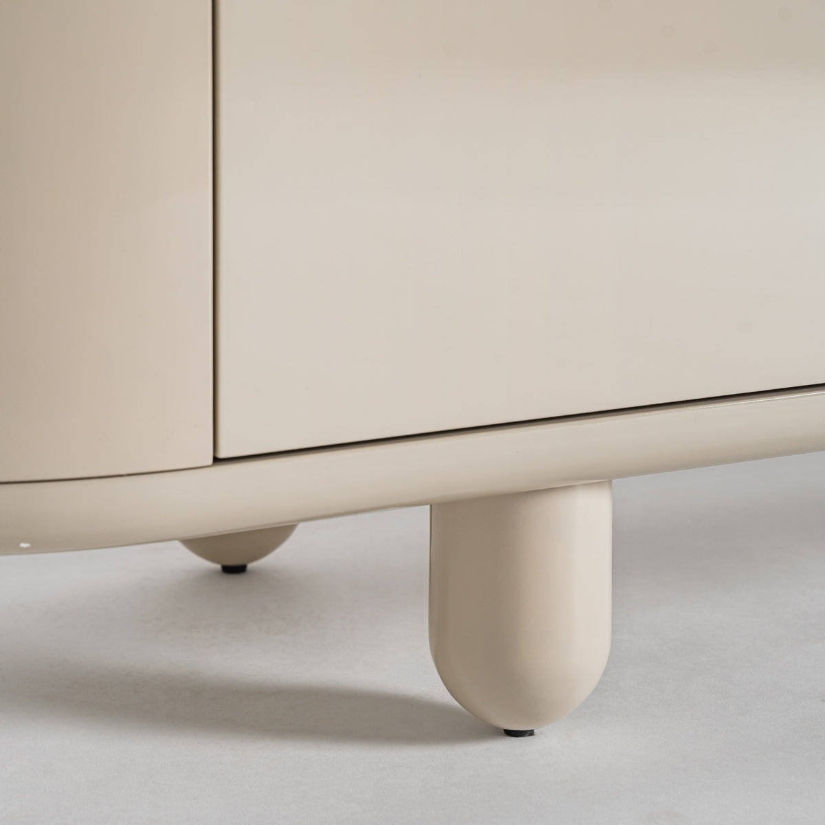 Pata redondeada lacada del mueble TV beige. Estilo moderno con formas suaves y armoniosas.