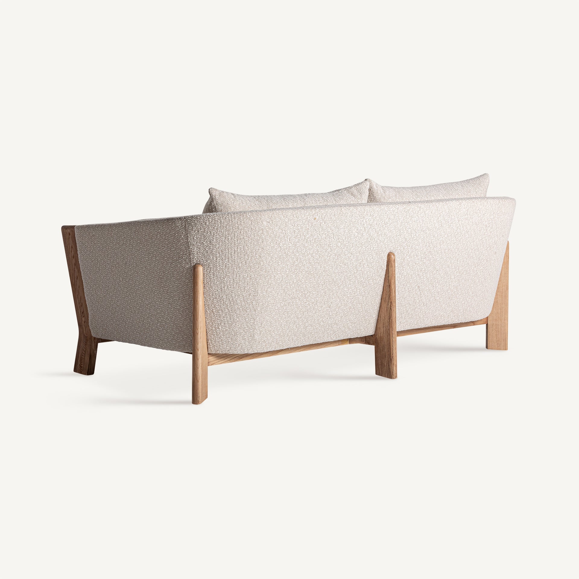 Parte trasera del Sofá Nara con respaldo tapizado y patas de madera, diseño elegante y cálido