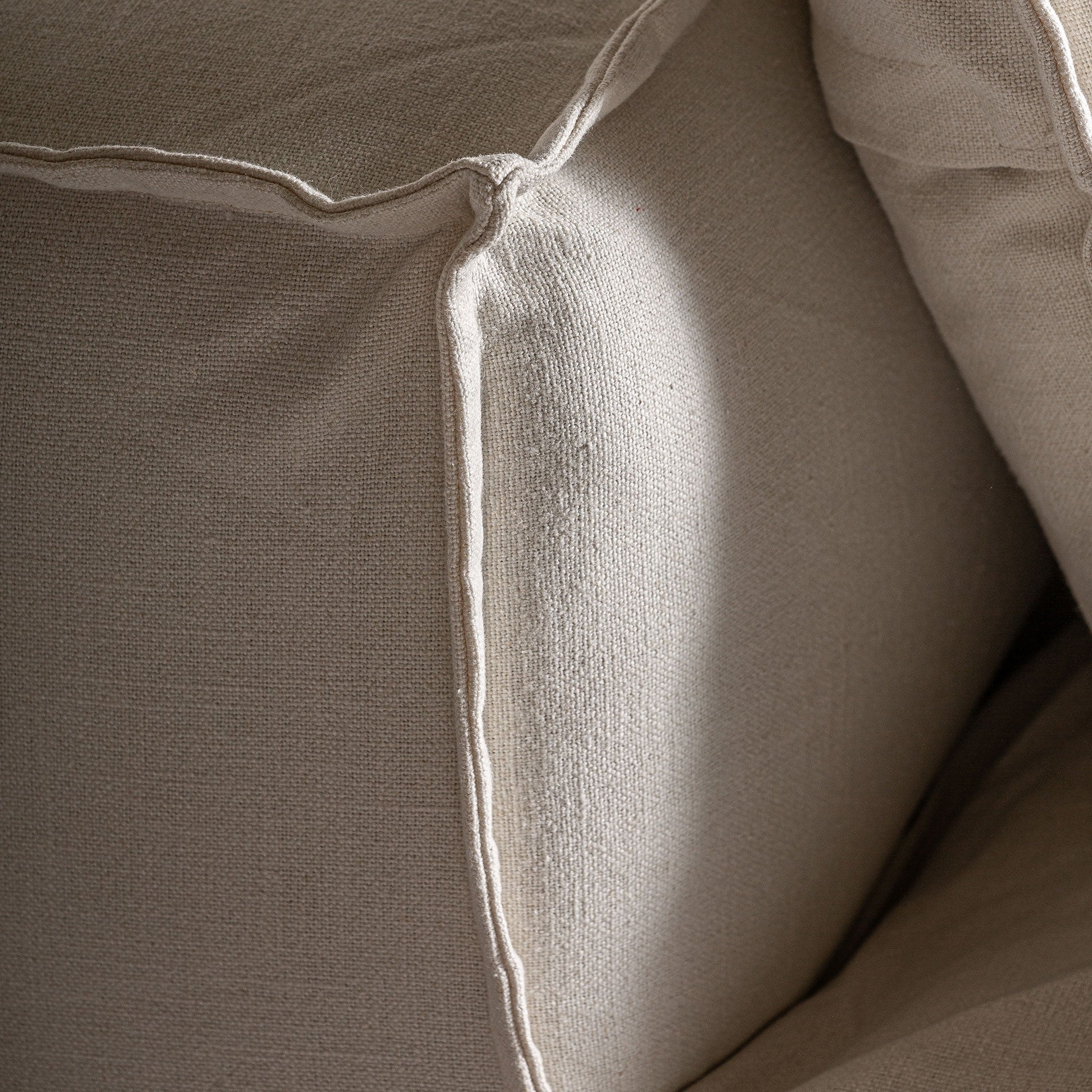 Detalle del respaldo y costuras del módulo Virolle en lino blanco, diseño envolvente boutique interiorismo vical