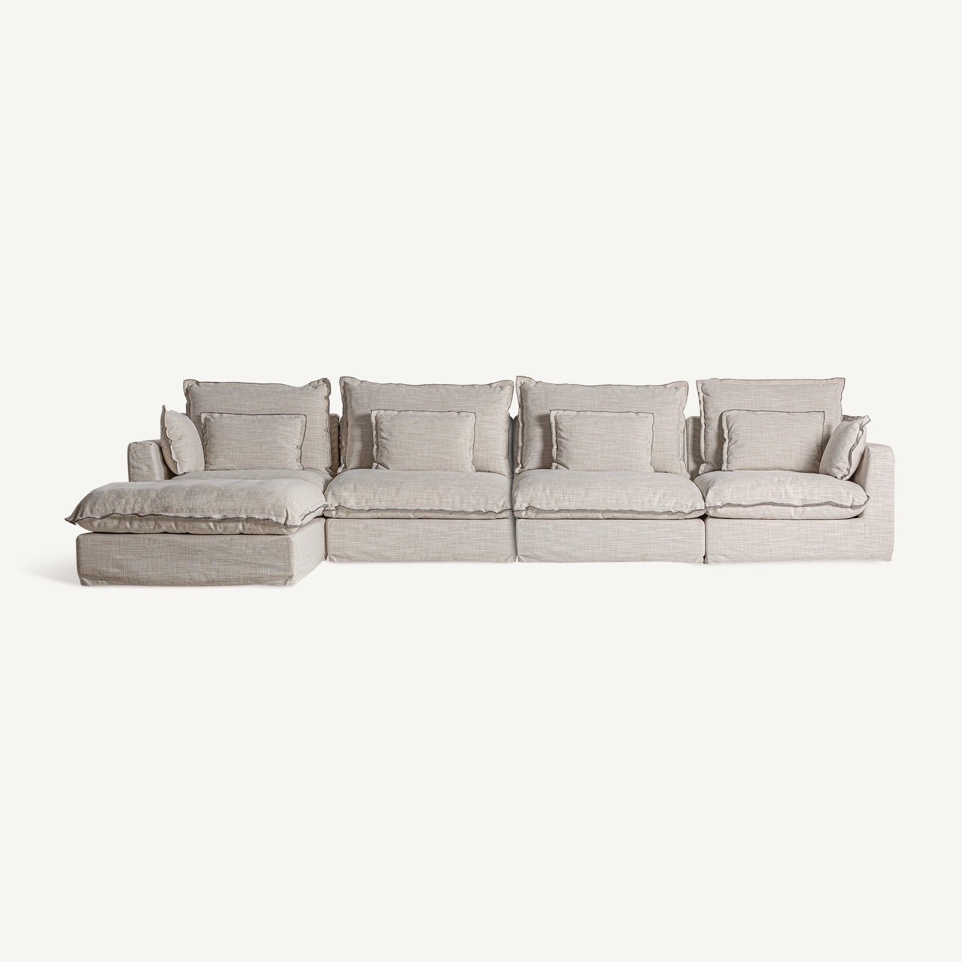 Sofá modular Bief en composición de cuatro piezas. Diseño envolvente, tapizado blanco roto. Ideal para grandes salones.