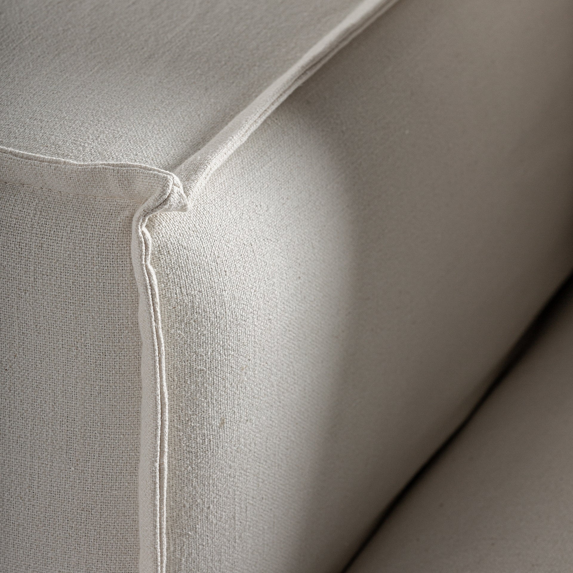 Detalle del brazo del módulo Virolle tapizado en lino blanco de textura suave boutique interiorismo vical