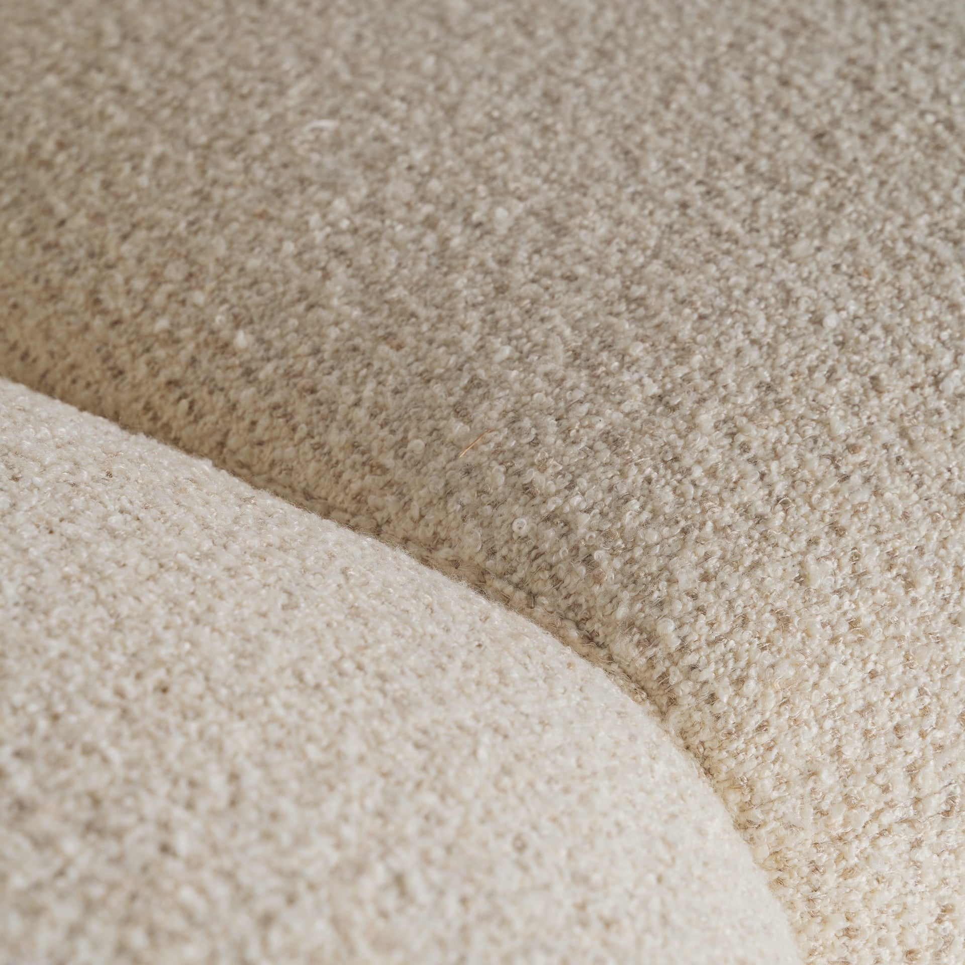 Detalle macro del tejido bouclé beige del sofá Zakupi, textura suave y cálida para un ambiente acogedor