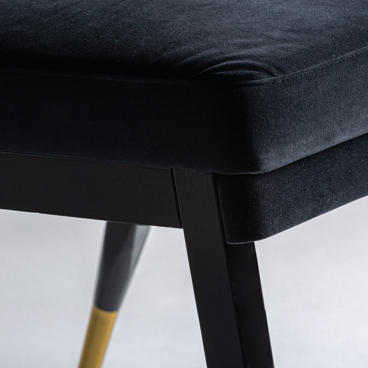 Plano detalle de la estructura dorada de la silla TRUN, contraste elegante con el negro boutique interiorismo vical