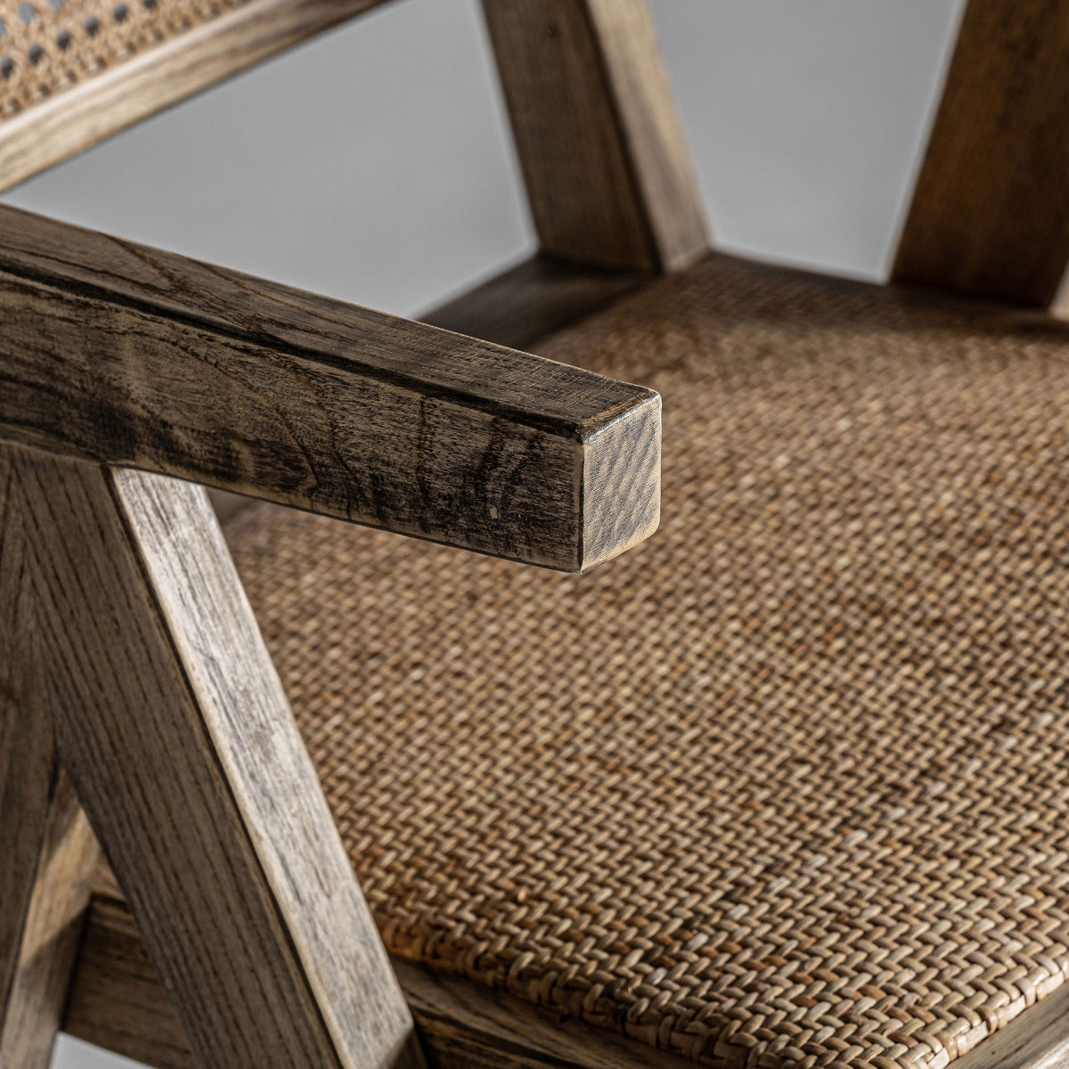Detalle del apoyabrazos en madera de olmo con vetas marcadas.