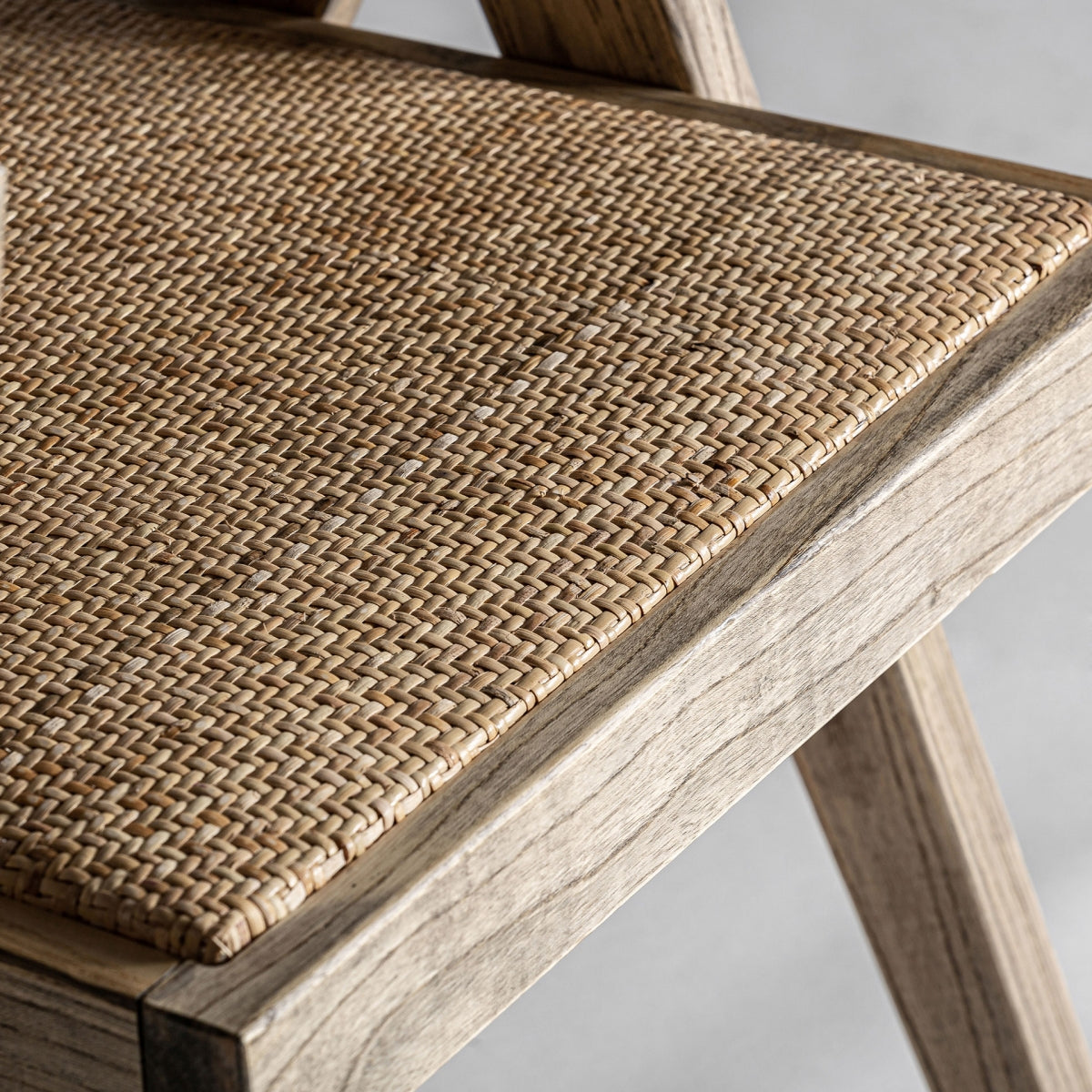 Vista superior del asiento y brazos de silla de ratán natural.