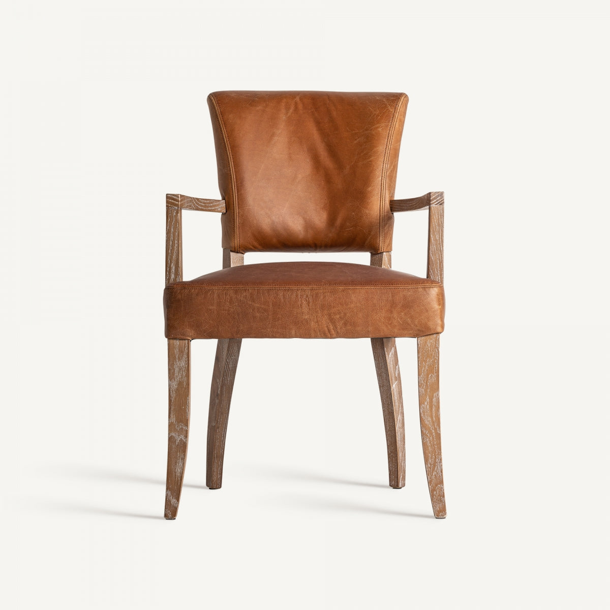 Silla completa con respaldo y brazos, tapizado en piel marrón y patas de madera clara, estilo colonial refinado.