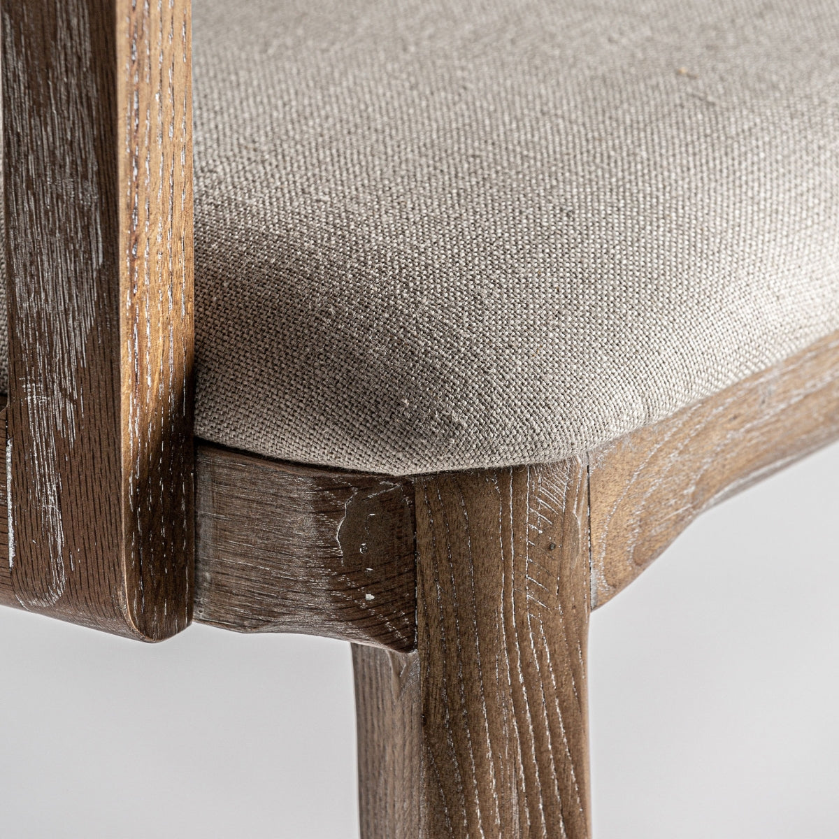 Primer plano del asiento tapizado en lino color crema sobre estructura robusta - boutique_interiorismo - vical