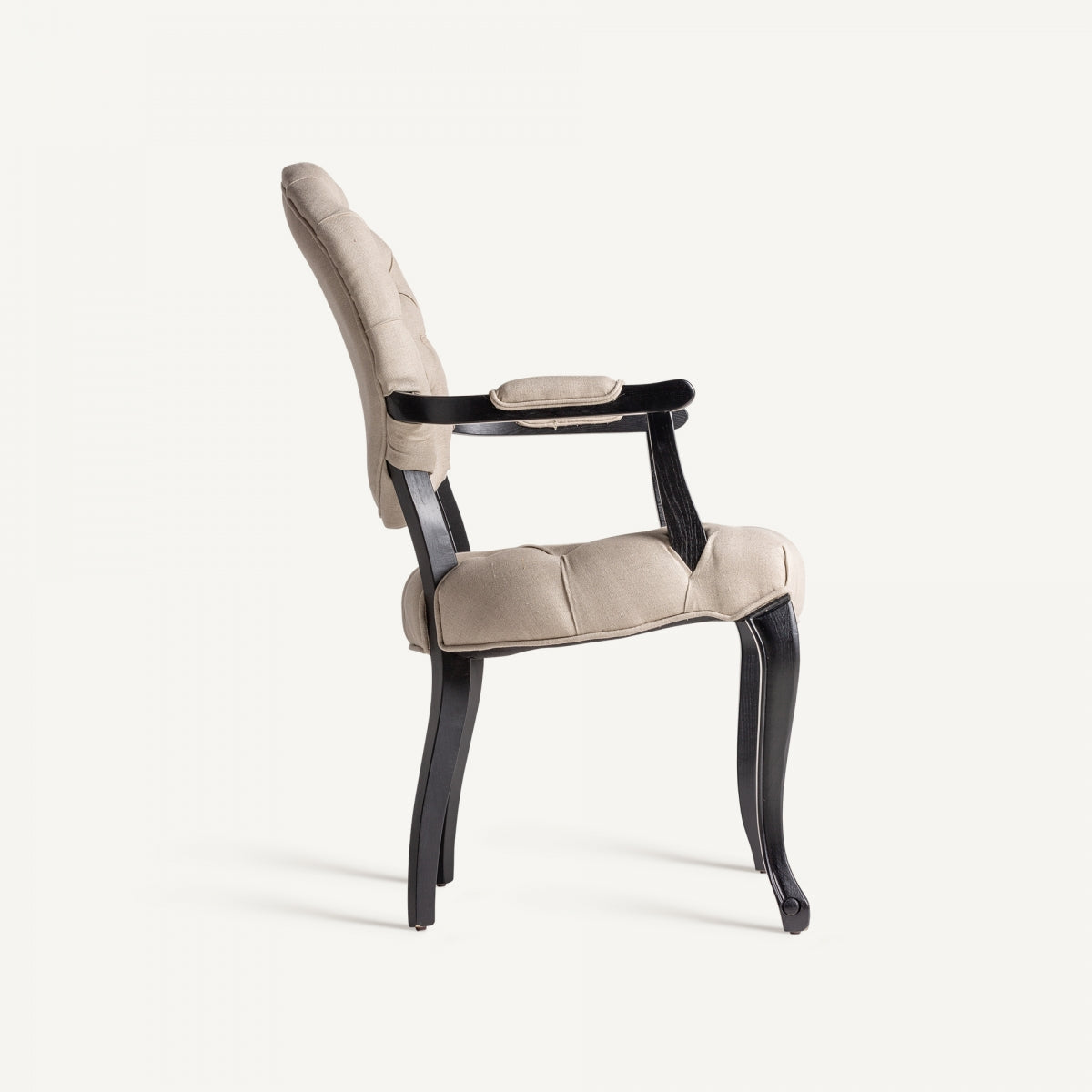 Vista lateral del sillón tapizado en lino beige con estructura negra de madera