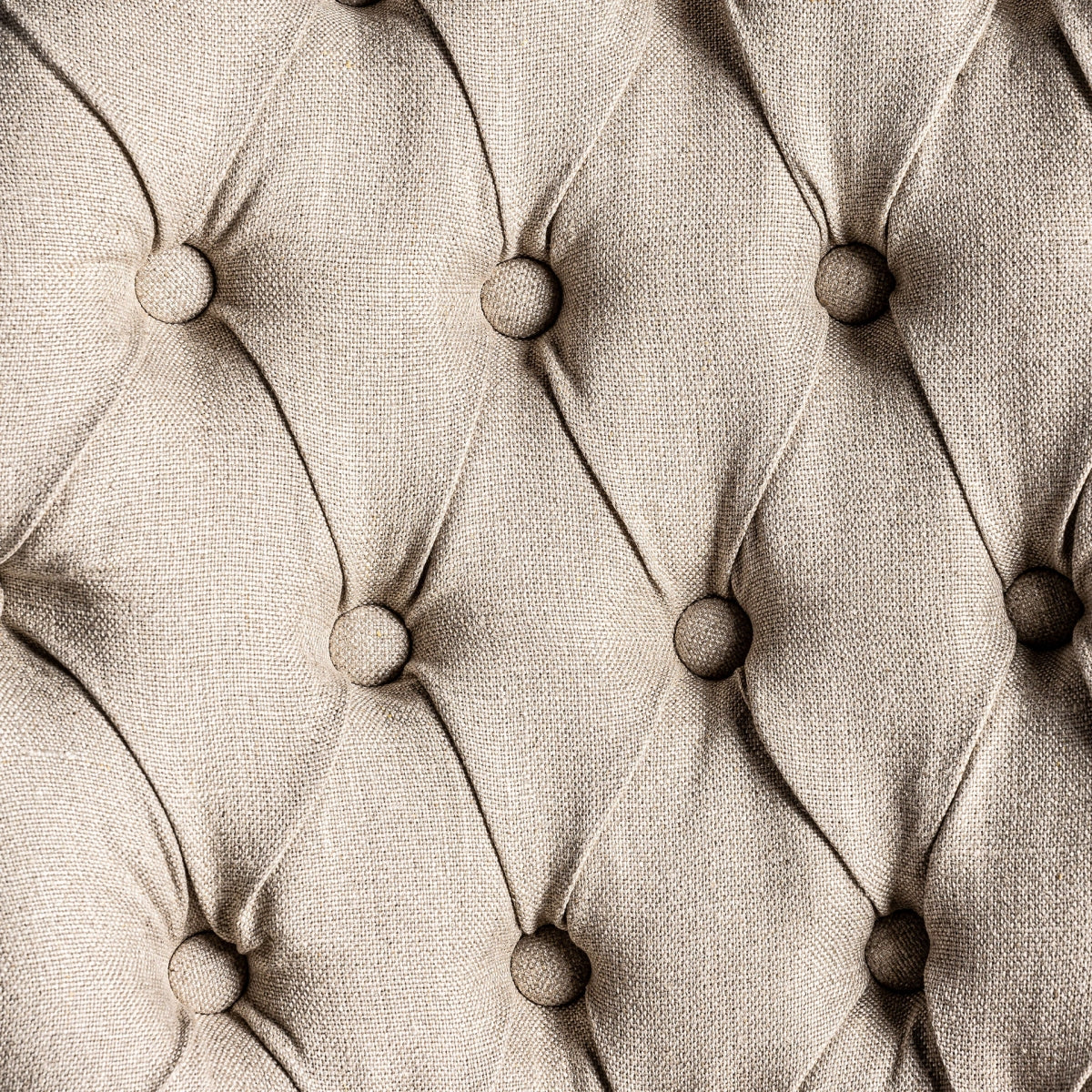 Respaldo con botones capitoné en tela beige, detalle decorativo de inspiración clásica