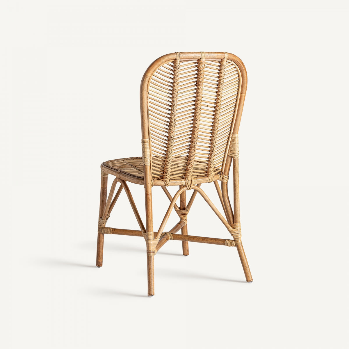 Vista trasera de silla de ratán natural, respaldo alto y forma redondeada, estilo artesanal
