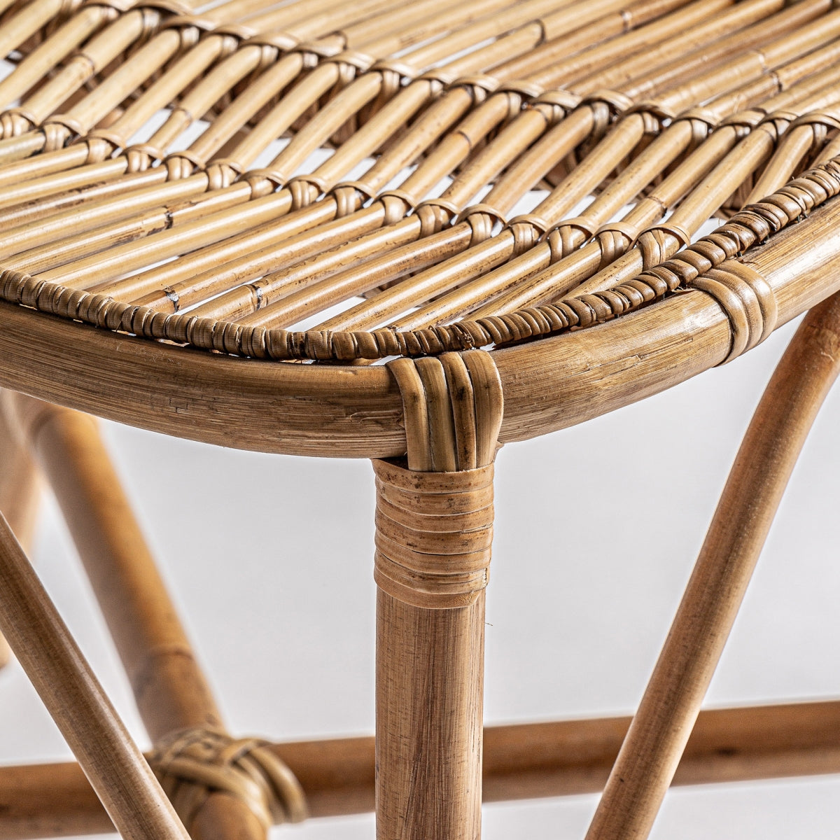 Detalle de asiento trenzado en ratán natural, textura orgánica y acabado natural