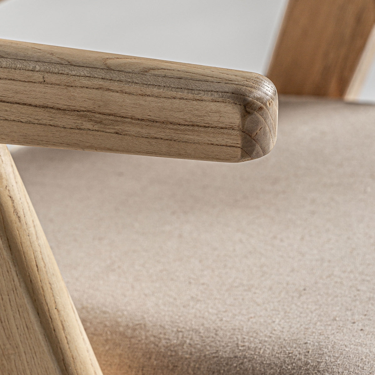 Detalle del brazo redondeado en madera natural, acabado suave y elegante