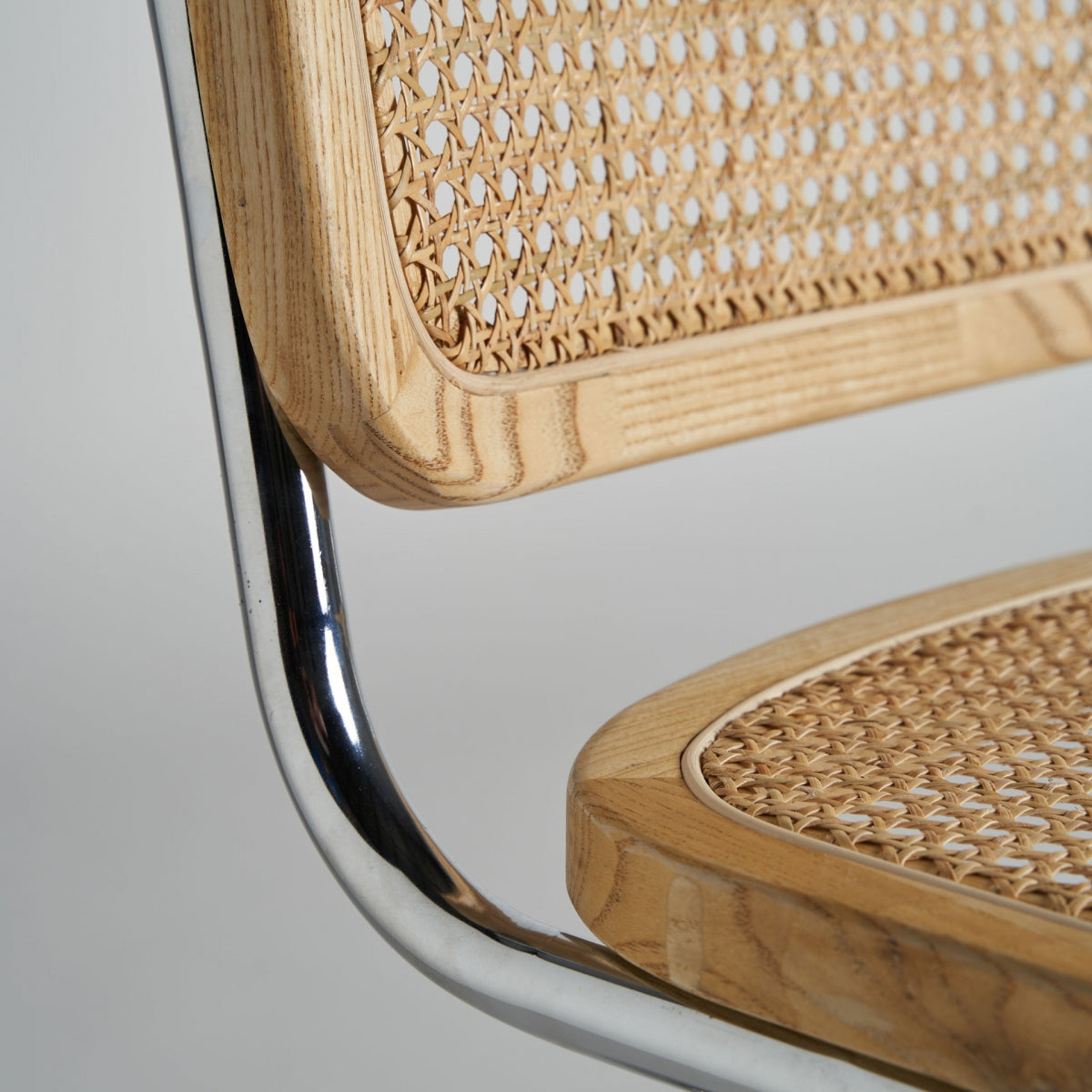 Silla Sins de ratán y madera en ambiente moderno con detalles en acero.
