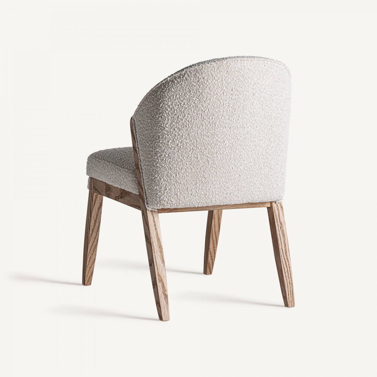 Detalle del respaldo curvo de la silla Prati, en tejido bouclé blanco y madera de pino.