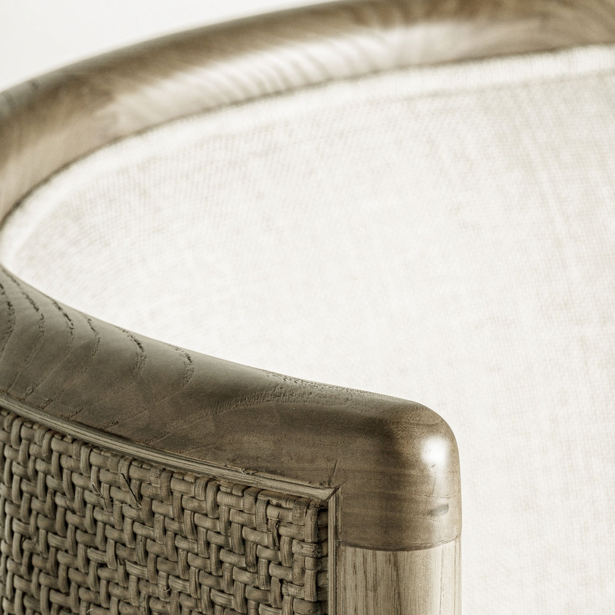 Detalle superior del respaldo curvo en madera suave, con remate artesanal.