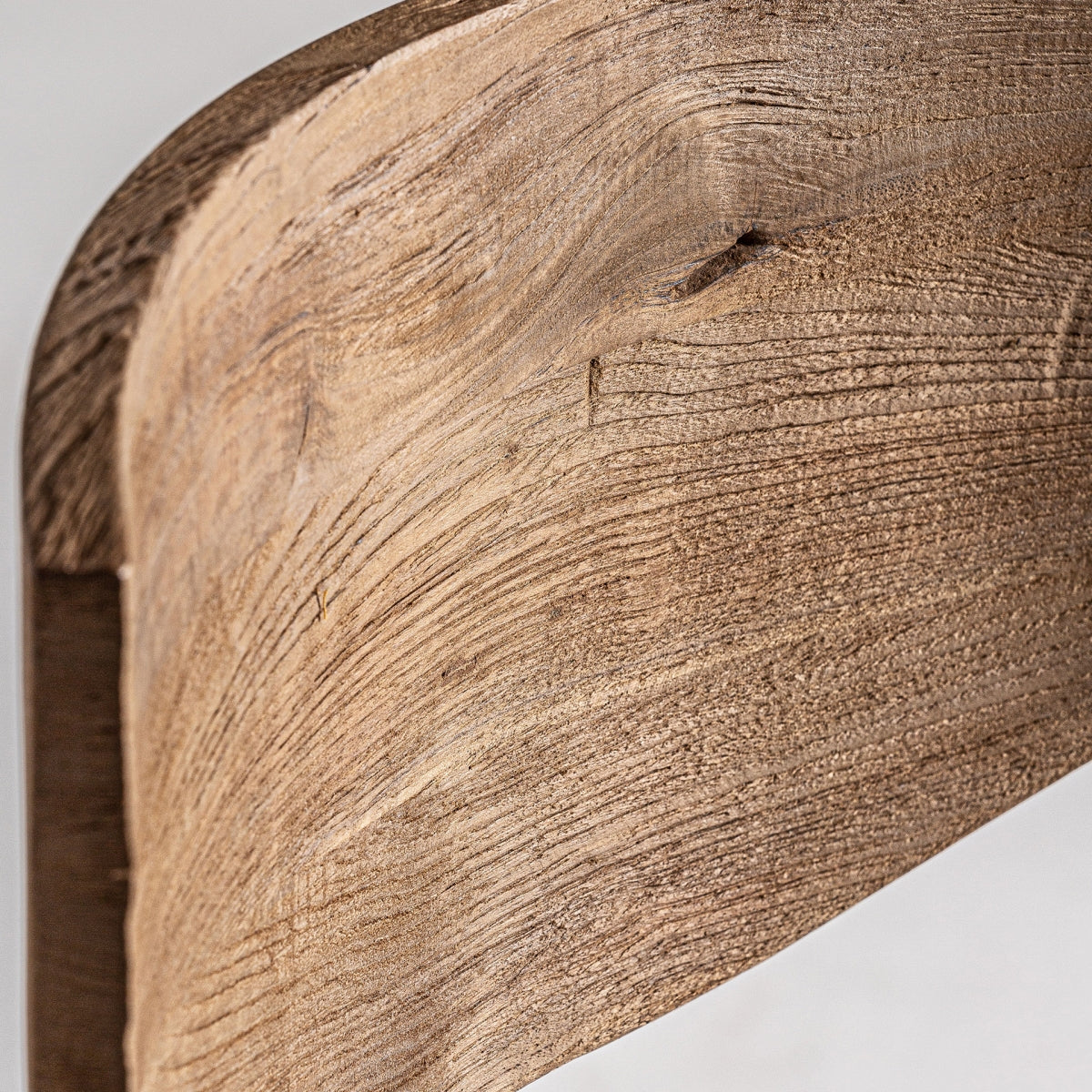 Detalle del respaldo curvo de madera natural, líneas suaves y cálidas