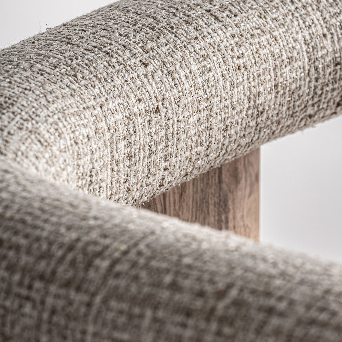 Curvatura del respaldo tapizado en bouclé beige con textura artesanal