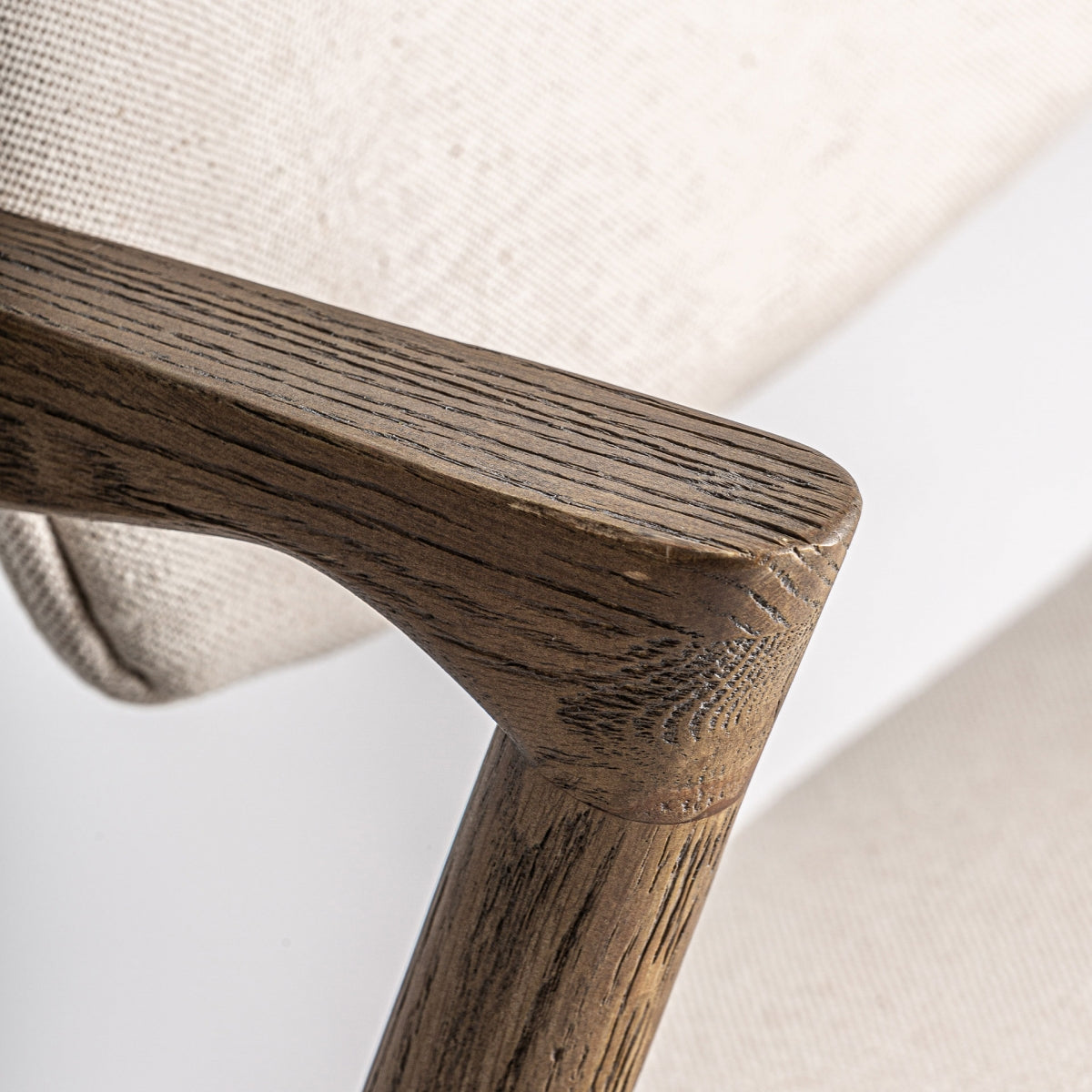 Brazo de silla en madera curva, acabado roble natural con vetas visibles.