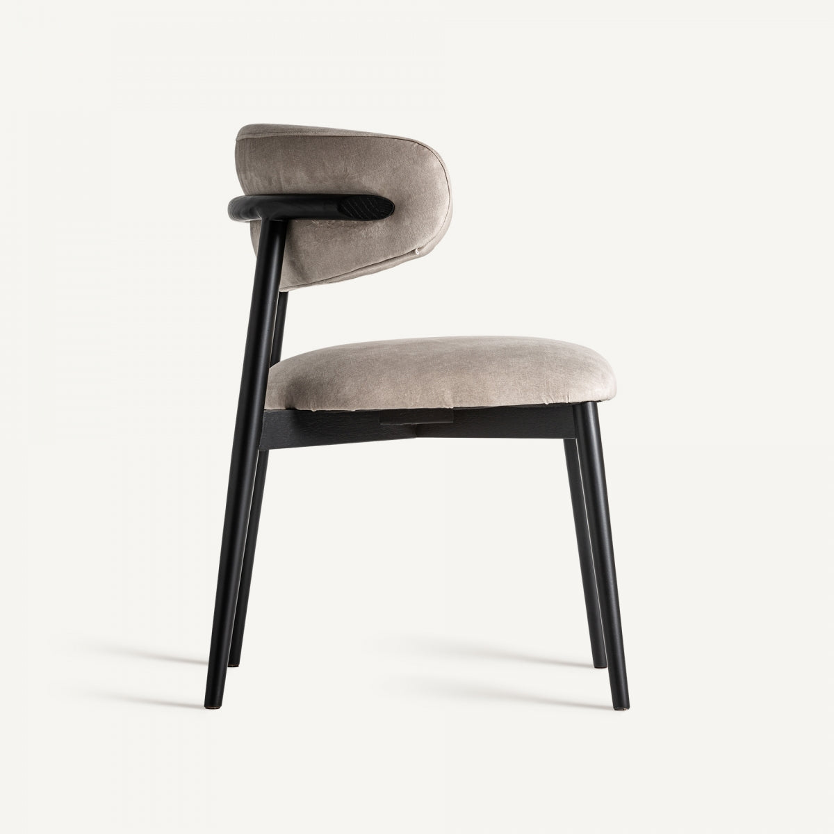 Vista lateral de silla tapizada en terciopelo beige con estructura negra, diseño moderno y envolvente