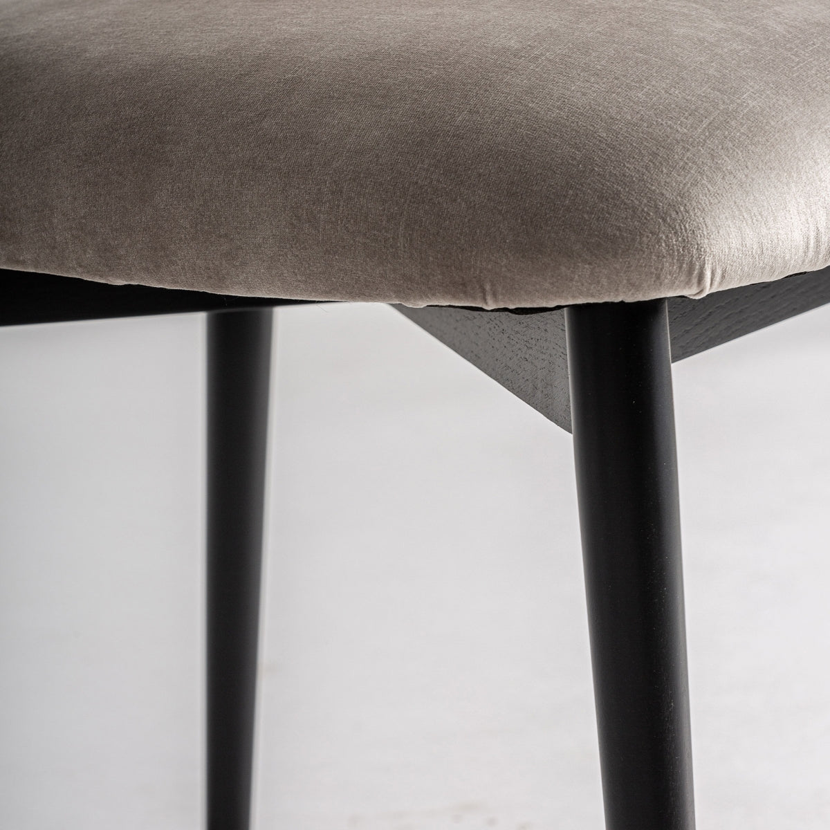 Primer plano del asiento en terciopelo beige, textura suave y cómoda, perfecta para comedores de diseño