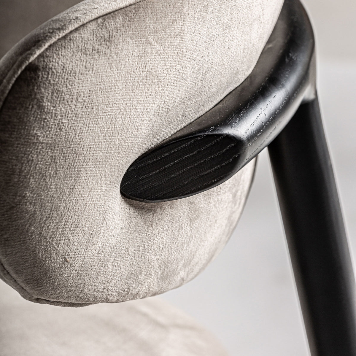 Detalle del punto de apoyo del respaldo, acabado en terciopelo y madera negra, estilo moderno y refinado