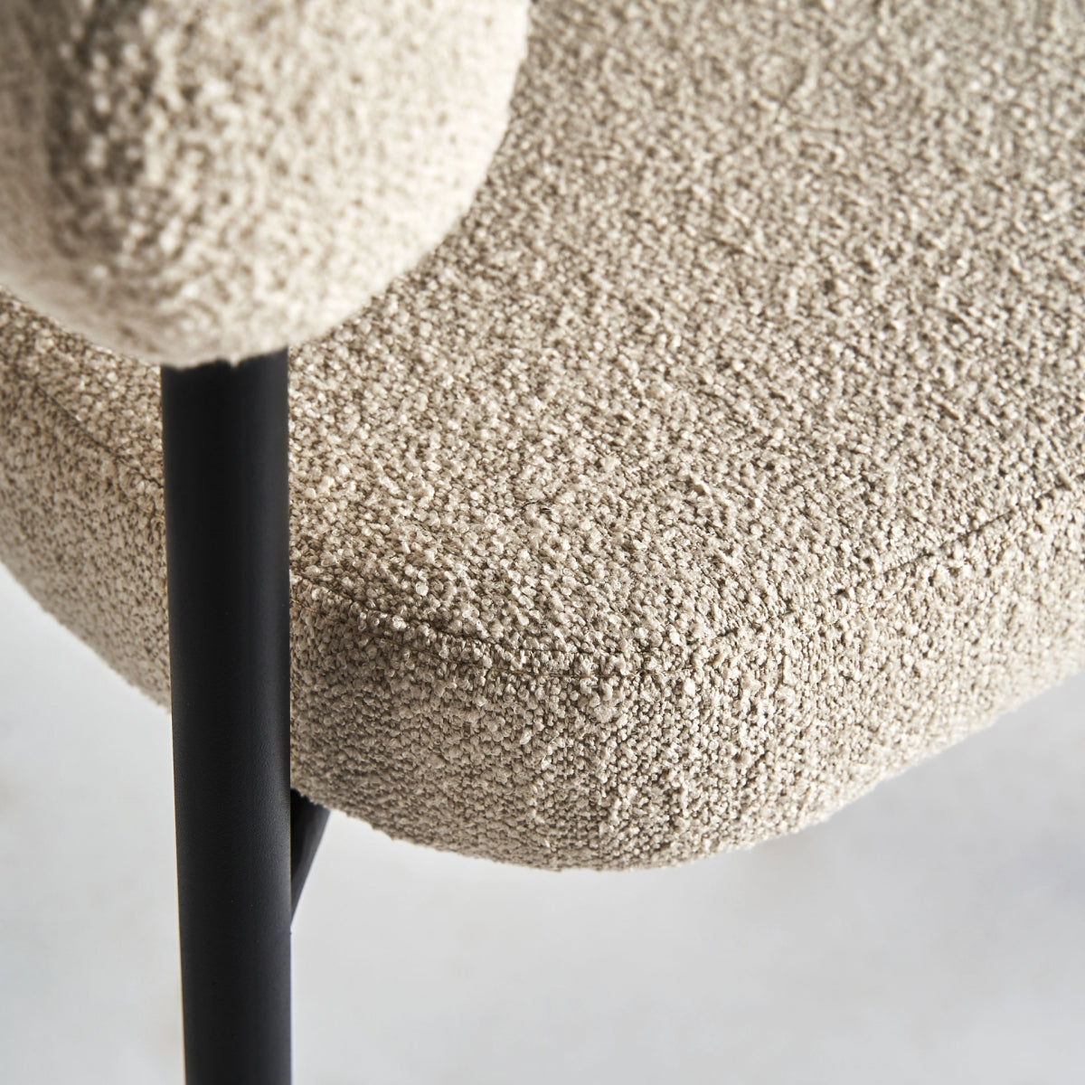Detalle cercano de la textura del tapizado bouclé en tono blanco roto, suave y elegante