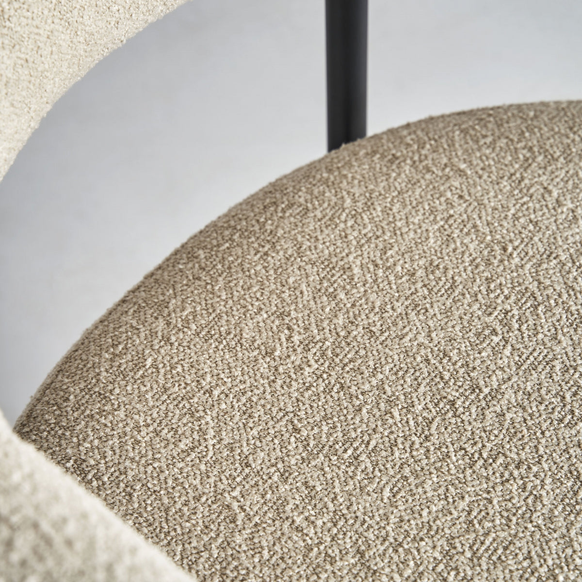 Vista superior del asiento de la Silla Albula, acolchado en bouclé blanco roto con estructura metálica negra