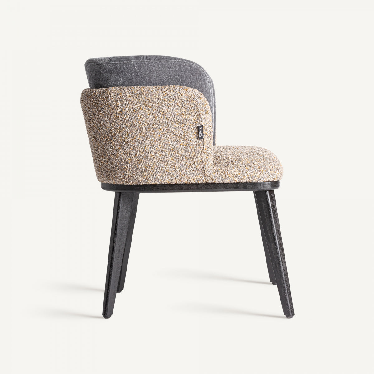 Perfil lateral de silla en mezcla de tejidos, patas negras y estructura curva, diseño art déco contemporáneo.