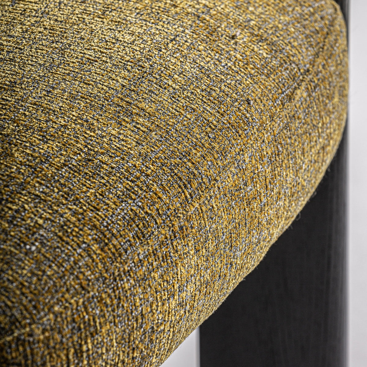 Detalle del tejido en mostaza jaspeado con textura suave, estilo moderno y acogedor.