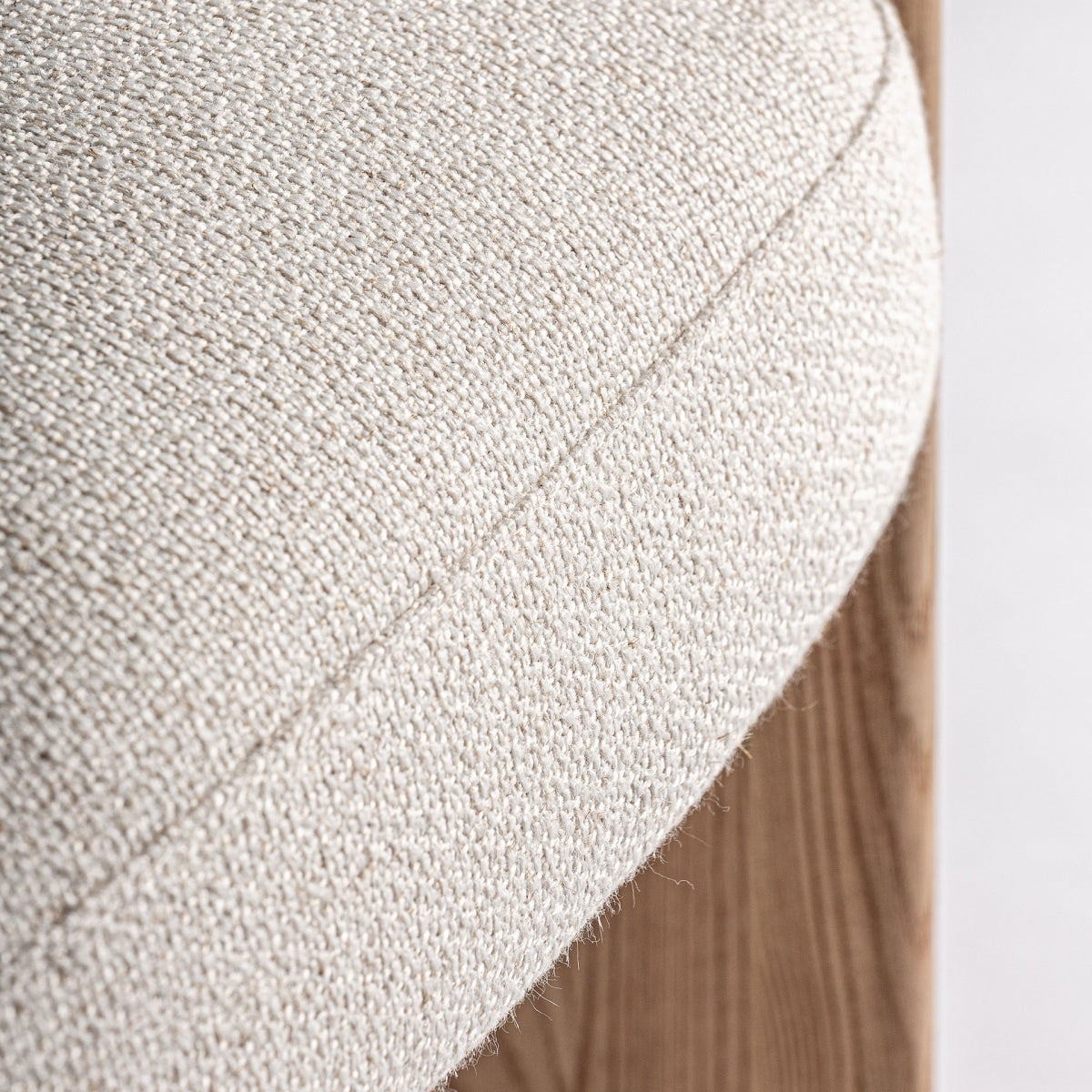 Primer plano de la costura del asiento tapizado en tono beige natural, acabado limpio