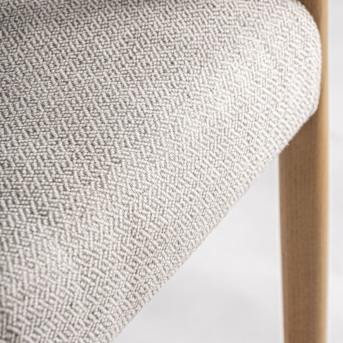 Detalle del tapizado en tejido beige con textura de espiga, elegante y moderno.