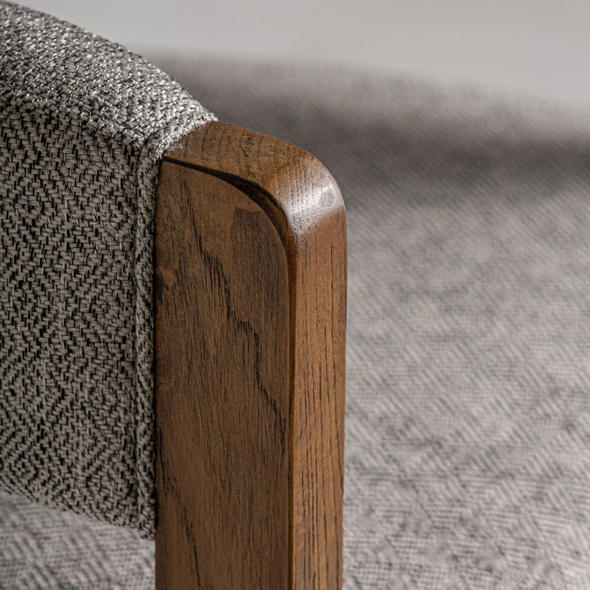 Primer plano del asiento acolchado de la silla Wizerne, tejido rizado y madera natural