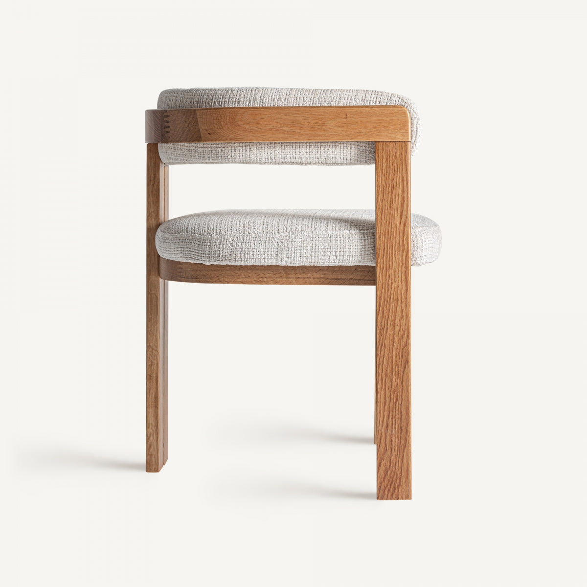 Vista lateral de silla con asiento tapizado y patas rectas de madera natural