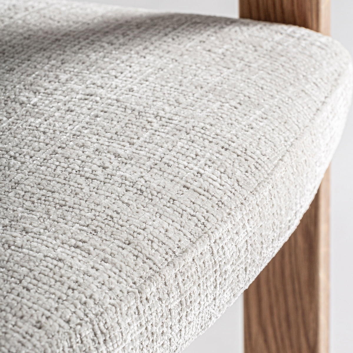 Detalle del asiento tapizado en tejido beige de textura gruesa y cómoda