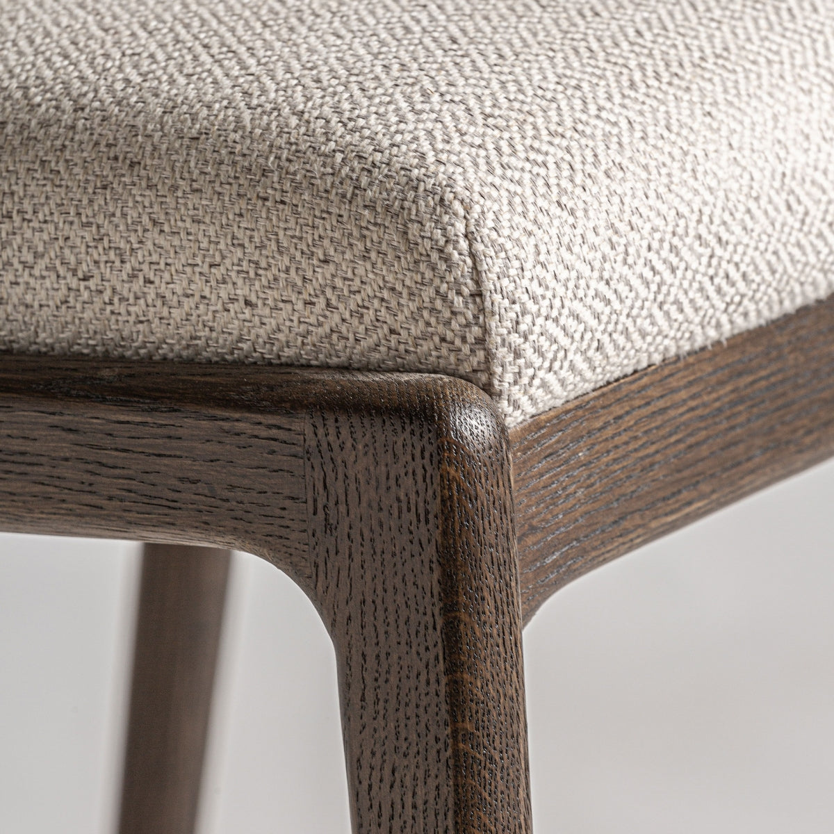 Primer plano del asiento tapizado en tejido beige, textura suave y neutra