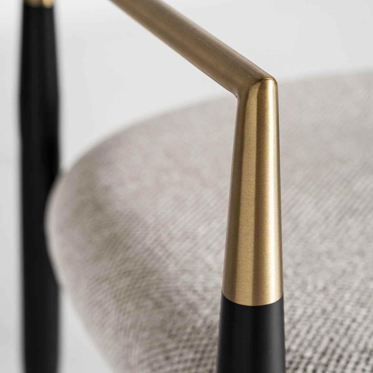Detalle del apoyabrazos de la silla Crossac en metal dorado de inspiración art déco.