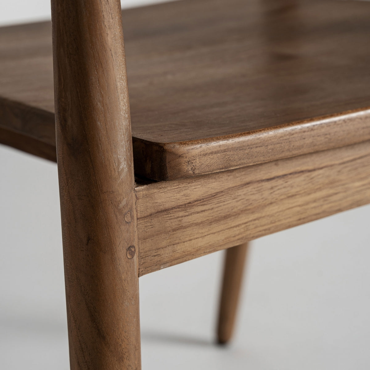 Detalle del brazo tallado de silla de madera maciza con acabado artesanal