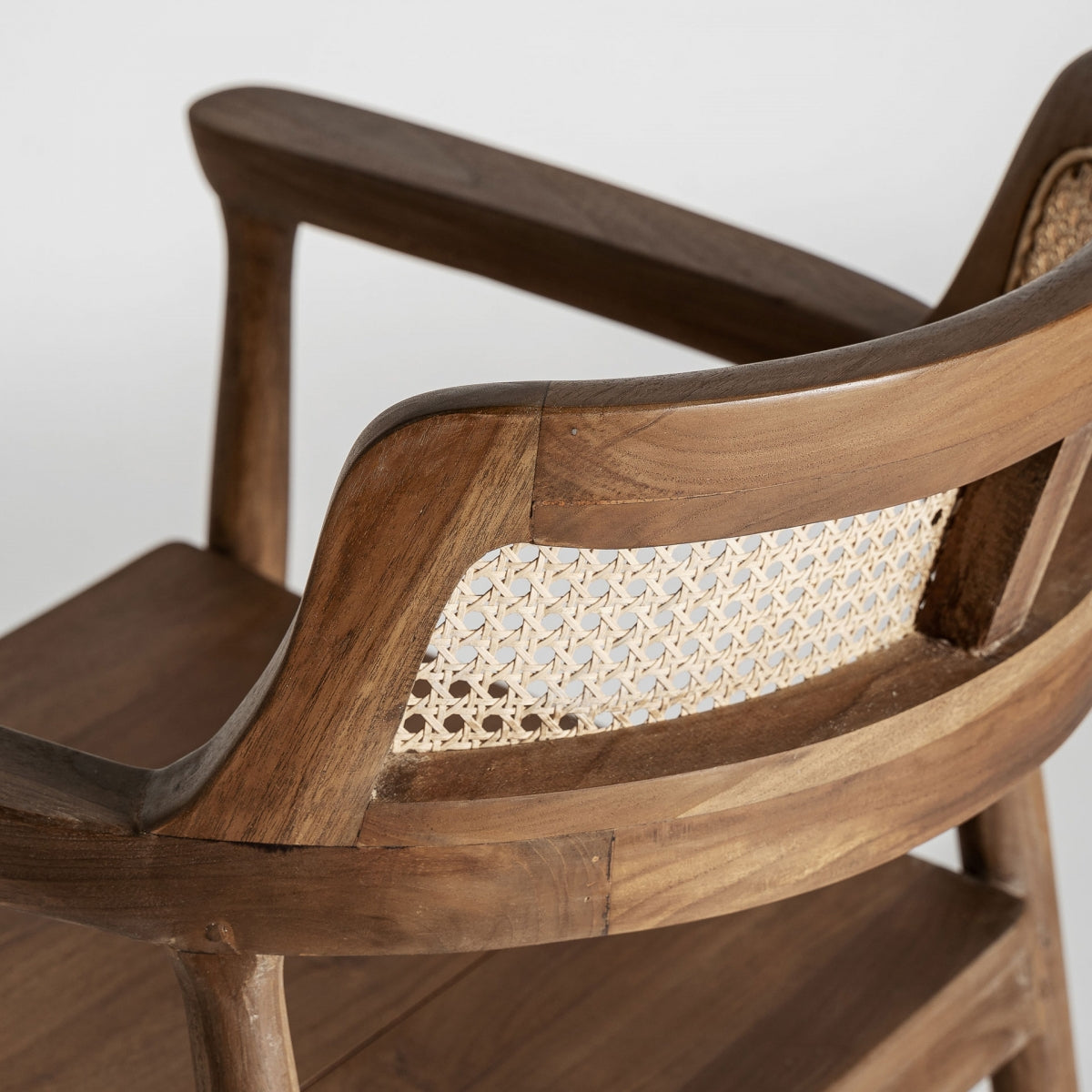 Vista trasera del respaldo en rejilla de ratán en silla de diseño cálido boutique interiorismo